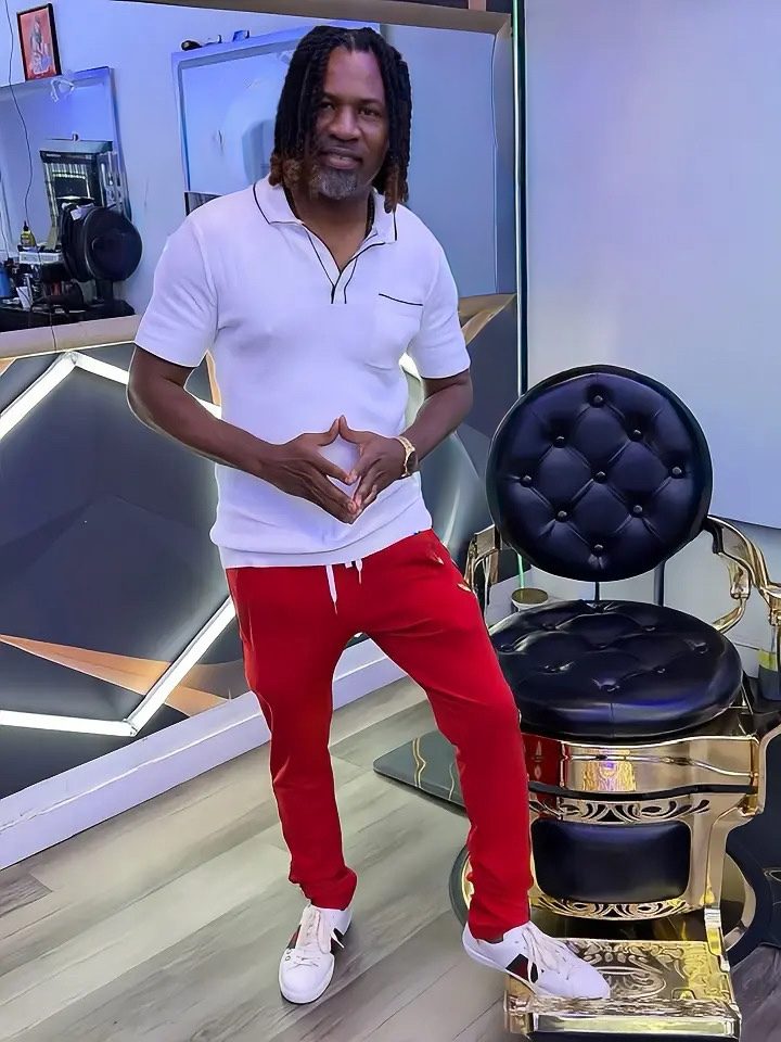 Rony standing beside a black and gold barber chair inside Rony's The Barbershop in Miramar